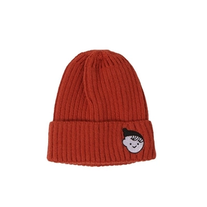 Terracotta knit beanie for kids featuring ribbed texture and smiling cartoon embroidery