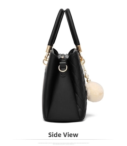 Side view of black handbag featuring diamond quilted stitching and faux pearl fur pom-pom