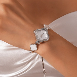 Close-up of a women's four-leaf clover quartz watch with pavé rhinestones on silk