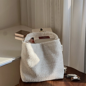 Gros plan détaillé sur la texture en tweed blanc d'un sac à main élégant et épuré