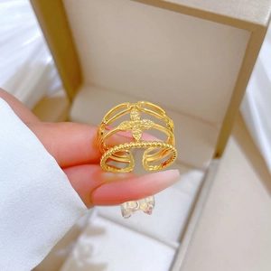 Minimalist gold clover open ring with hollow layers and crystals on a jewelry box