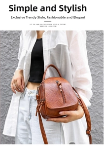 Detail view of brown PU leather bag with multi-zipper layers and textured finish