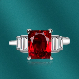 Macro shot of silver ring with large emerald-cut pink zircon and baguette side stones