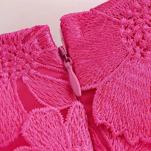 Détail macro de la broderie de dentelle florale rose et fermeture éclair invisible sur robe