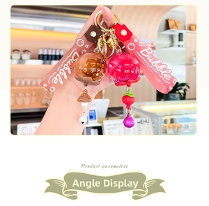 Detail of glitter keychain with silicone wristband and mushroom charm in hand