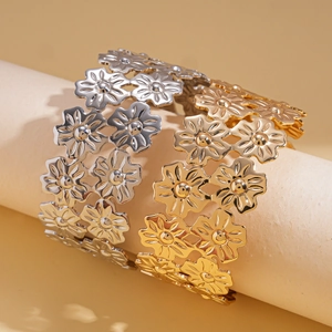 Chic gold and silver hollow flower layered open cuff bracelets in a minimalist display