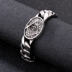 Macro shot of silver punk bracelet featuring Masonic symbols and steel chain links