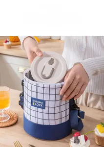 Detail of insulated cylindrical lunch bag with plaid pattern and adjustable shoulder strap