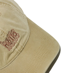 Detail of khaki washed cotton baseball cap featuring brown embroidered hello text