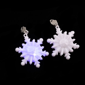 Macro detail of snowflake earrings showing unlit white and glowing LED light effects