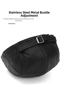 Close-up of adjustable stainless steel buckle on black textured leather newsboy cap