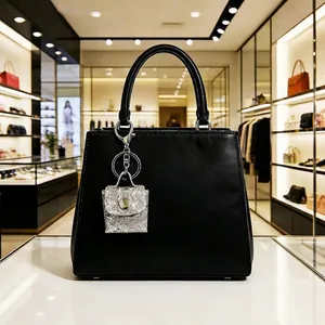 Black leather handbag with silver sequin mini charm accessory and top handle