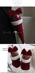 Close-up of red fleece Christmas flower wrap with white faux fur trim and bow detail