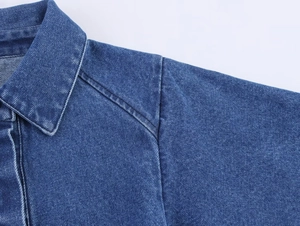 Detail eines blauen Jeanshemds mit hochwertigen Nähten und Twill-Stofftextur
