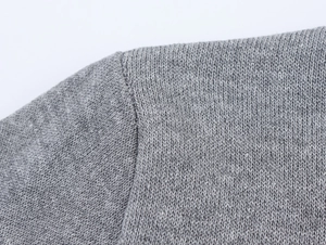 Détail macro de la couture d'épaule plate et texture tricotée fine d'un haut gris foncé