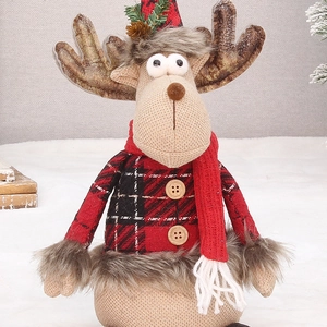 Close-up of plush Christmas reindeer doll with red plaid sweater and pine cone hat detail