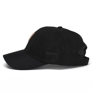 Detail of black quick-dry baseball cap featuring breathable mesh fabric and brown leather patch