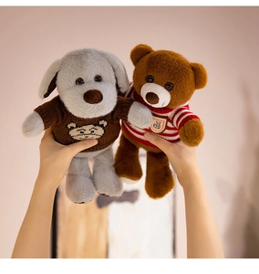Détail d'un ours et d'un chiot en peluche en pulls tricotés tenus dans les mains