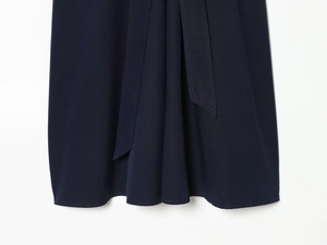 Gros plan sur l'ourlet de la robe bleu marine avec ceinture assortie et tissage détaillé