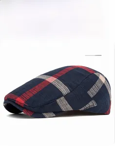 Detailed view of the red and blue plaid pattern fabric on a stylish newsboy cap