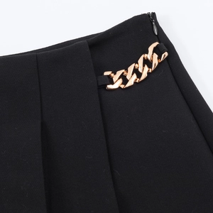 Detailansicht der schwarzen Shorts-Taille mit goldener Kette und Reißverschluss