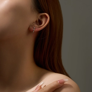 Close-up of S925 sterling silver hoop earrings with pave-set zircon on woman's ear