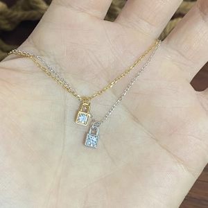 Detail of 925 sterling silver padlock necklaces in gold and silver with zircon insets
