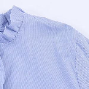 Close-up of ruffled neckline and shoulder detail on a blue striped poplin shirt
