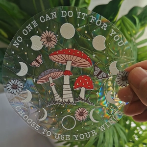 Close-up of holographic mushroom and butterfly suncatcher sticker with rainbow effect