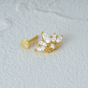 Macro shot of S925 sterling silver stamp on fan-shaped gold cartilage piercing jewelry