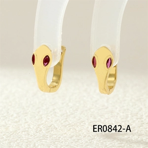 Macro shot of cobra hoop earrings with red gemstone eyes in gold finish detail