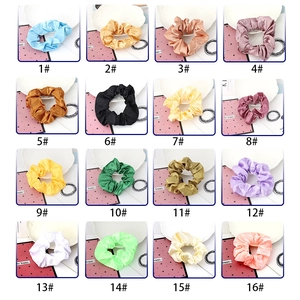 Grid display of 16 solid color satin scrunchies with a smooth silk texture for hair