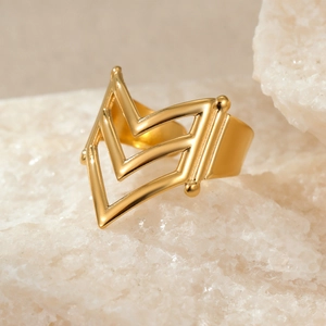 Macro shot of 18k gold plated stainless steel V-shaped open ring on white stone