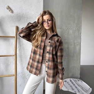Détail d'une chemise à carreaux avec grande poche et boutons dans un style décontracté