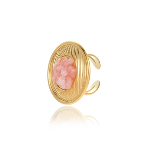 Macro detail of golden textured round ring featuring natural pink stone cluster on white
