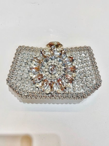 Close-up of luxury silver evening clutch with crystal flower detail and rhinestones