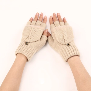 Dettaglio guanti in maglia beige con patta, chiusura a bottone e trama a trecce