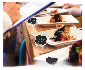 Mini wooden chalkboard signs with wavy edges used as buffet food labels for party decor