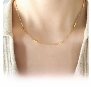 Close-up of minimalist 18k gold plated titanium steel necklace worn on model neck