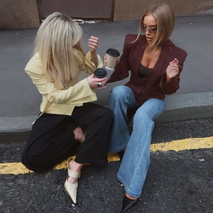 Outdoor street style shot of models wearing slim-fit button blazers in high-quality fabric