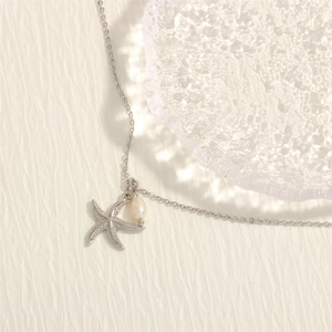 Detailed view of starfish pendant and white pearl on elegant 18K gold-plated necklace