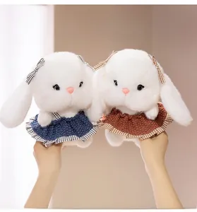 Detailed macro view of white plush rabbit dolls in crochet dresses with plaid bow accents
