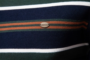 Detail of multi-color striped knit sweater with premium metal logo and fine texture