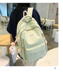 Détail d'un sac à dos vert menthe en tissu froissé avec bretelles et pendentif en peluche