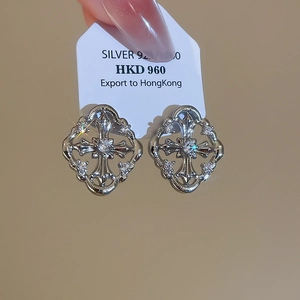 Macro detail of S925 silver earring with hollow rhombus frame and zircon cross inlay