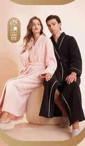 Detail of couple's plush fleece bathrobes in pink and black with white piping trim