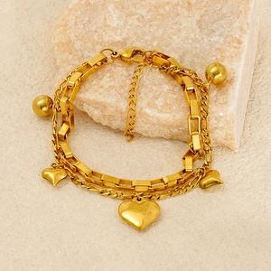 Détail d'un bracelet double couche en titane doré avec cœurs sur une pierre naturelle