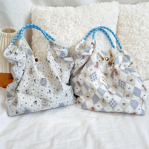 Close-up of blue and white seersucker tote bags with cartoon puppy and bear patterns