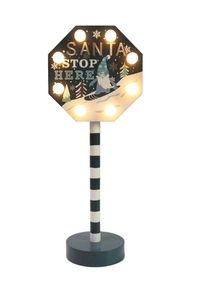 Macro view of Santa Stop Here LED wooden road sign with snowflakes and elf details