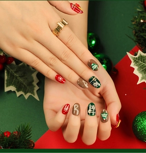 Detailed view of Christmas press-on nails with red green patterns and snowflakes